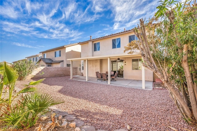 rear view of house featuring a fenced backyard, a ceiling fan, a patio, and stucco siding