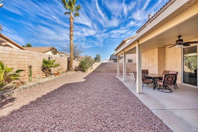 view of yard with ceiling fan, outdoor dining space, a patio area, and a fenced backyard