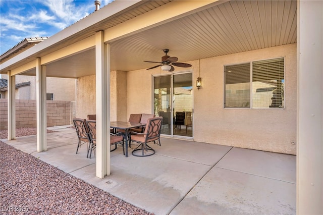 view of patio featuring fence, outdoor dining area, and a ceiling fan