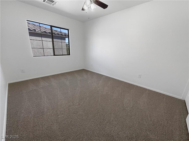 unfurnished room with visible vents, dark colored carpet, a ceiling fan, and baseboards