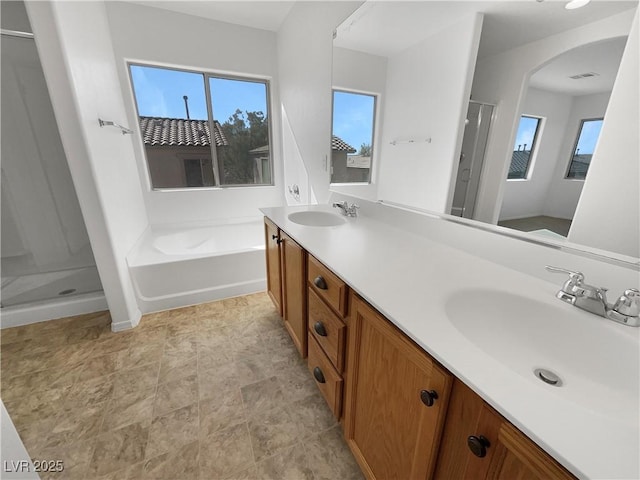 bathroom featuring a sink, a wealth of natural light, and a shower stall