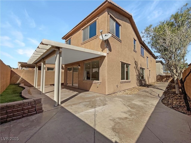 rear view of property featuring a patio area, a fenced backyard, and stucco siding