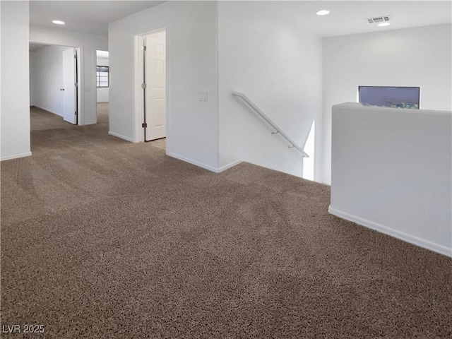 carpeted empty room with baseboards, visible vents, and recessed lighting