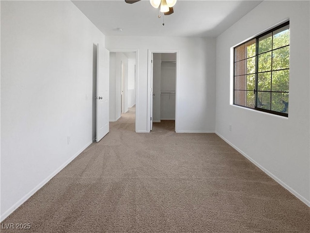 unfurnished bedroom with a ceiling fan, a closet, baseboards, and carpet flooring