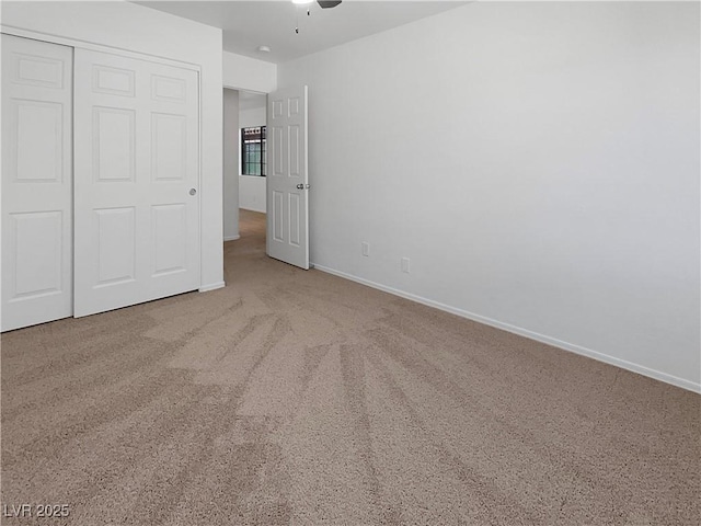 unfurnished bedroom featuring carpet floors, a ceiling fan, baseboards, and a closet