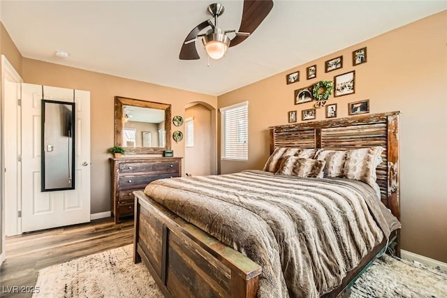 bedroom featuring light wood-style flooring, baseboards, and ceiling fan