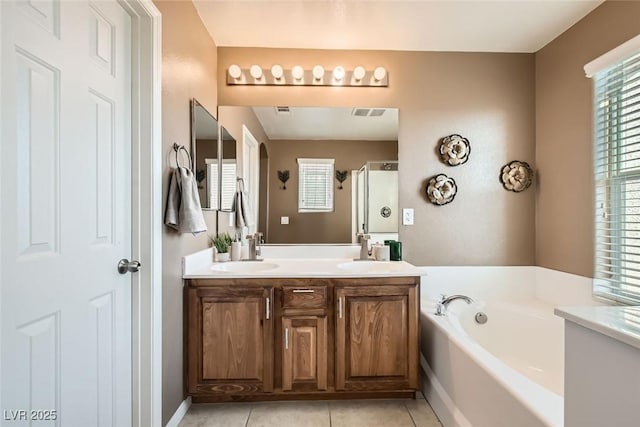 full bathroom with double vanity, a stall shower, a sink, tile patterned flooring, and a bath