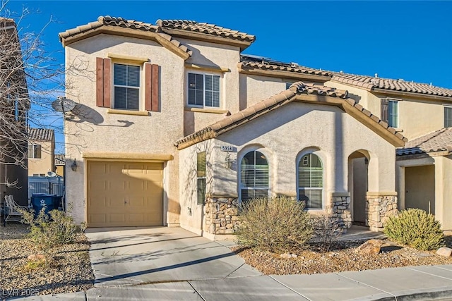 mediterranean / spanish-style home with a garage, driveway, stone siding, and stucco siding