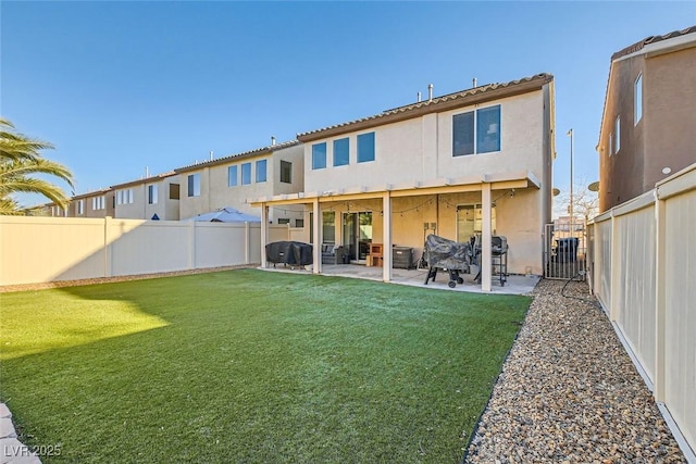 rear view of house with a yard, a patio, a fenced backyard, and stucco siding