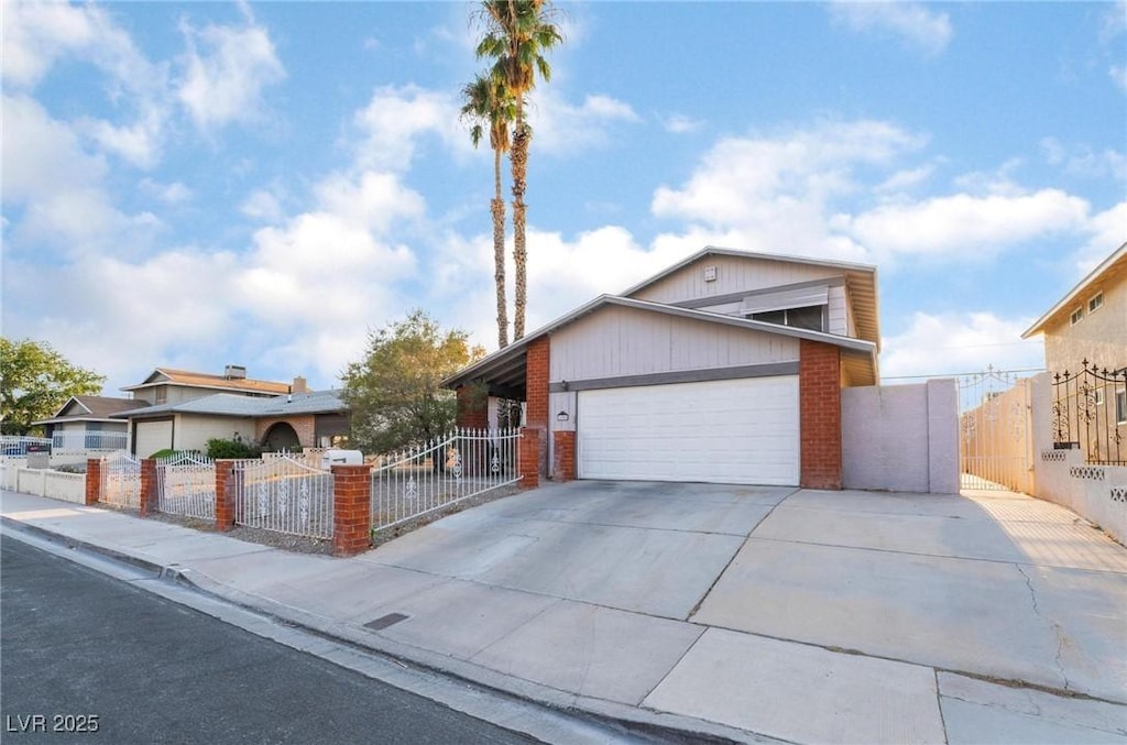 view of front of house with driveway, brick siding, a fenced front yard, and an attached garage