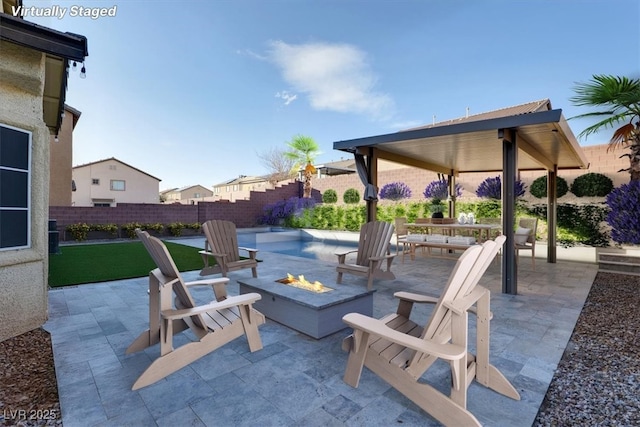 view of patio with a fenced backyard and a fire pit