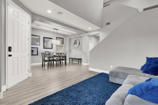 living room featuring baseboards, visible vents, wood finished floors, and recessed lighting