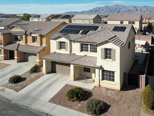 view of front of house featuring stucco siding, concrete driveway, a mountain view, fence, and a residential view