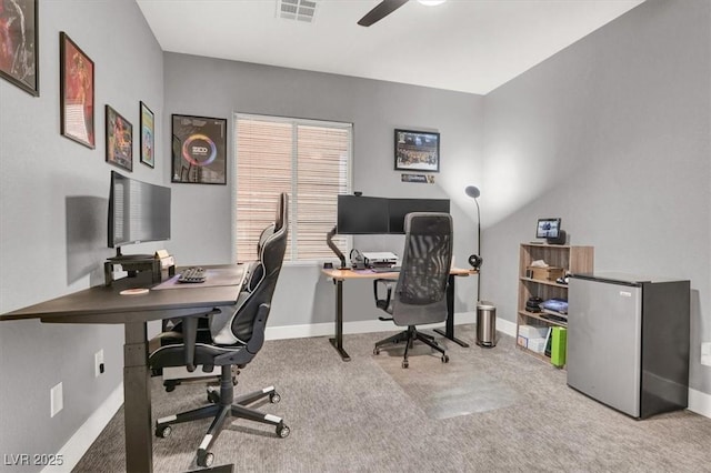 office featuring a ceiling fan, carpet, visible vents, and baseboards