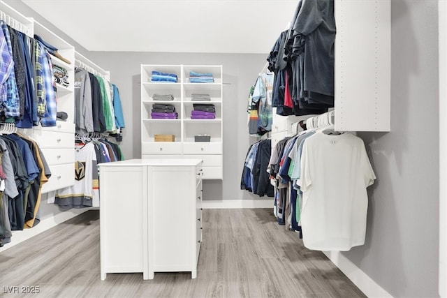 walk in closet with light wood-style flooring