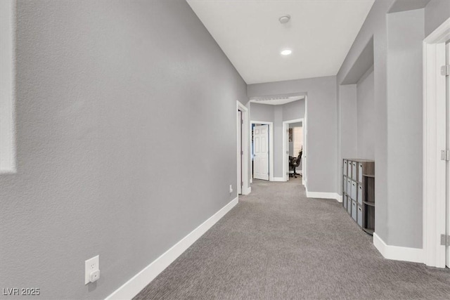 corridor with carpet flooring and baseboards