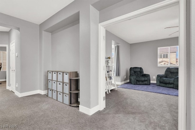 hallway featuring carpet floors and baseboards