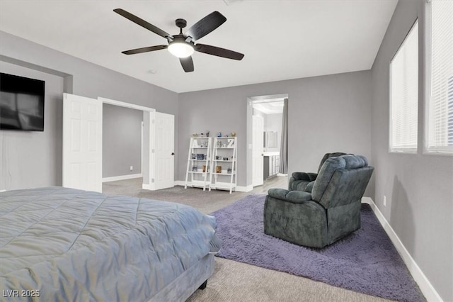 carpeted bedroom with ceiling fan, baseboards, and ensuite bathroom