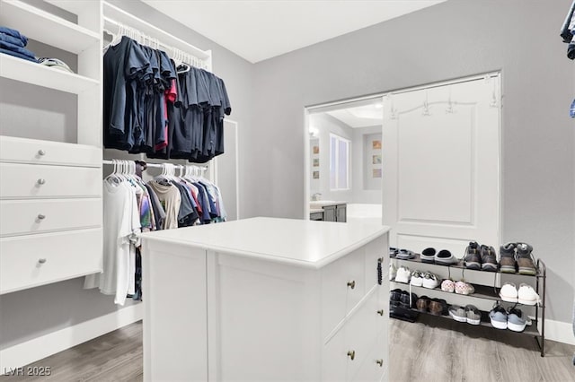 walk in closet with wood finished floors