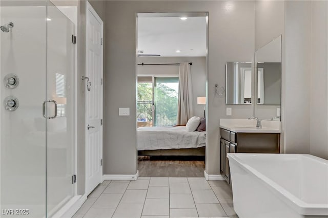 ensuite bathroom with a stall shower, connected bathroom, tile patterned floors, a freestanding bath, and vanity