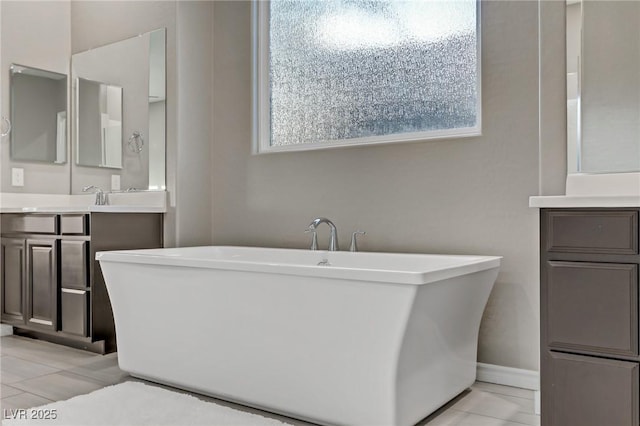 bathroom featuring tile patterned flooring, a freestanding bath, and vanity