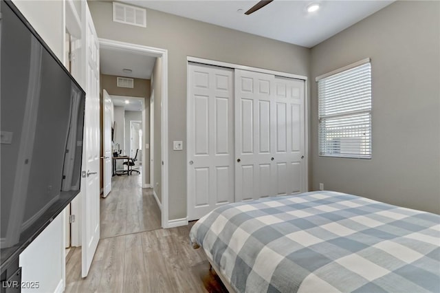 bedroom featuring light wood-style floors, a closet, visible vents, and baseboards