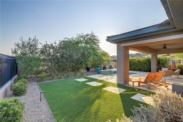 view of yard with ceiling fan, a patio, a fenced backyard, and a fenced in pool