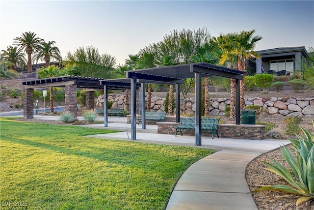 view of community featuring a yard, a patio, and a pergola