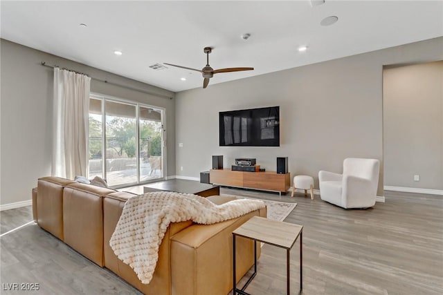 living room featuring ceiling fan, recessed lighting, visible vents, baseboards, and light wood-type flooring