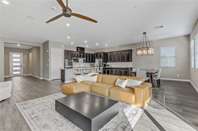 living area with a wealth of natural light, light wood finished floors, and visible vents