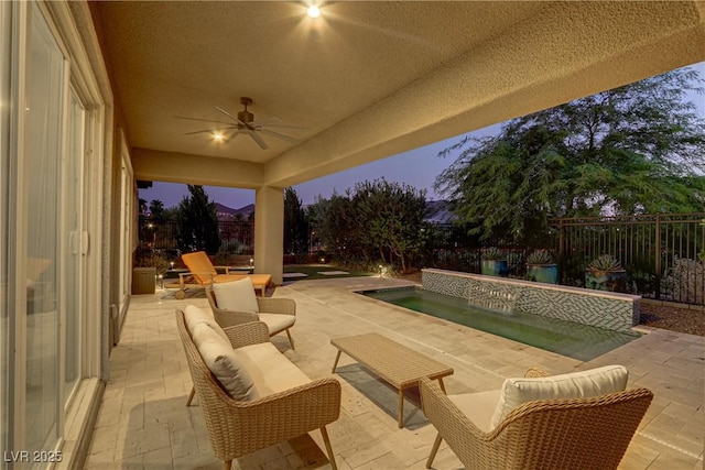 view of patio featuring ceiling fan, a fenced backyard, and an outdoor living space