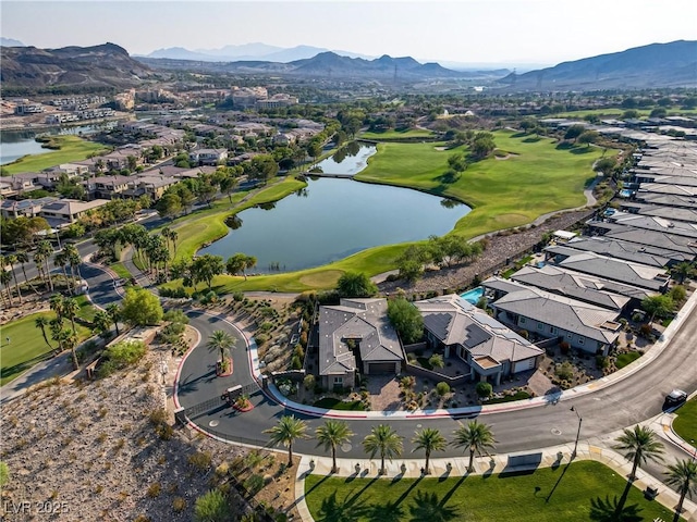 drone / aerial view with view of golf course and a water and mountain view