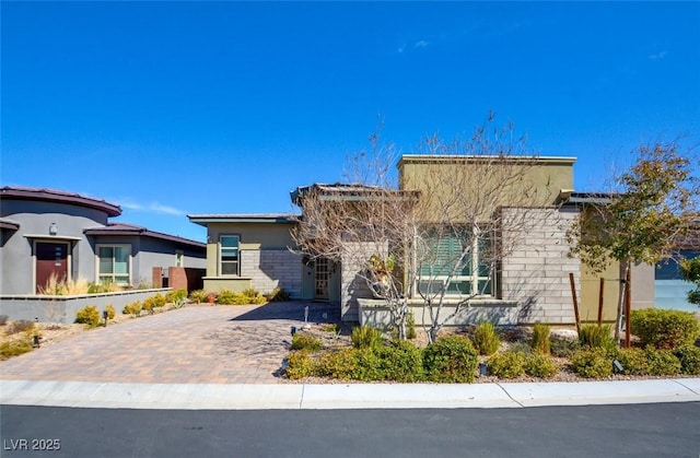 view of front of home featuring decorative driveway and stucco siding