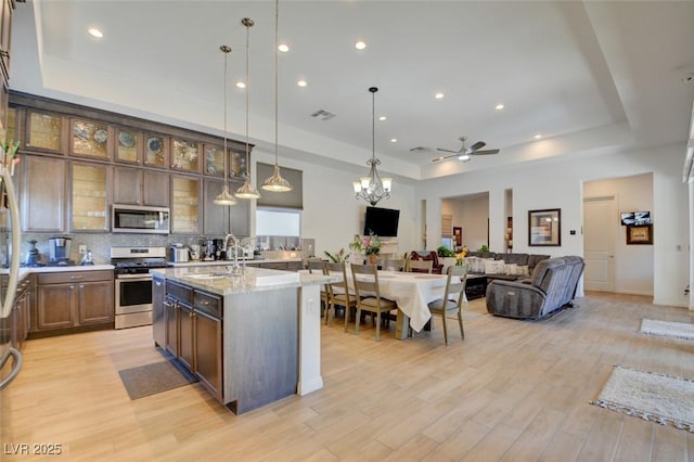 kitchen featuring visible vents, appliances with stainless steel finishes, tasteful backsplash, and a tray ceiling