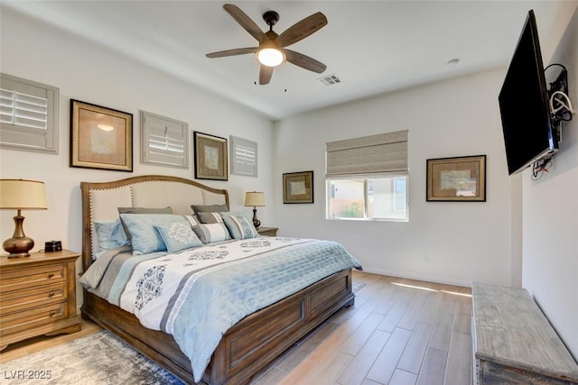 bedroom featuring light wood-style flooring, visible vents, and a ceiling fan