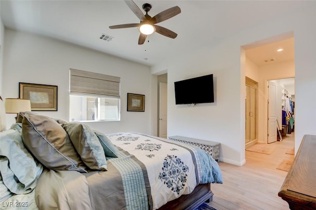 bedroom featuring light wood-type flooring, baseboards, visible vents, and ceiling fan