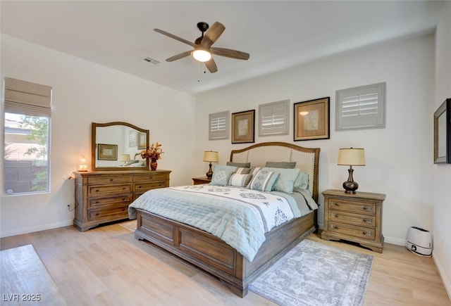 bedroom featuring ceiling fan, light wood finished floors, visible vents, and baseboards