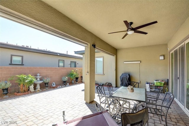 view of patio / terrace with outdoor dining area, fence, and a ceiling fan