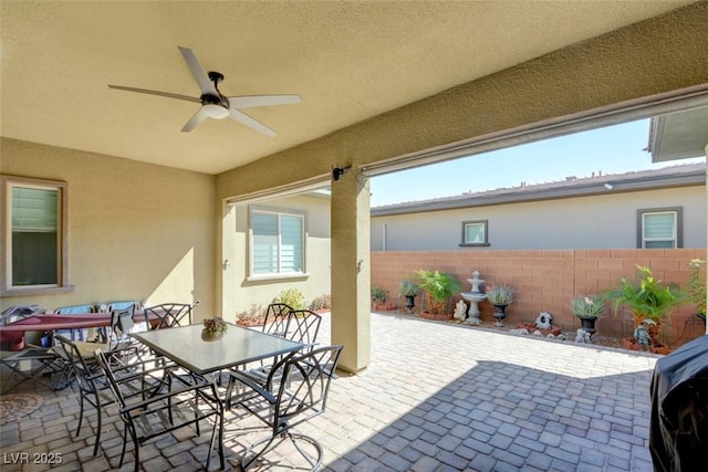 view of patio featuring ceiling fan, fence, and outdoor dining space