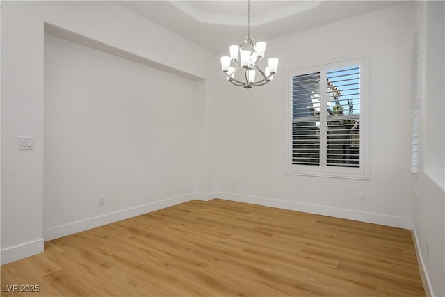 2265 Lauren Dr, Las Vegas, NV 89134 - empty room with a chandelier, light wood-style flooring, a tray ceiling, and baseboards