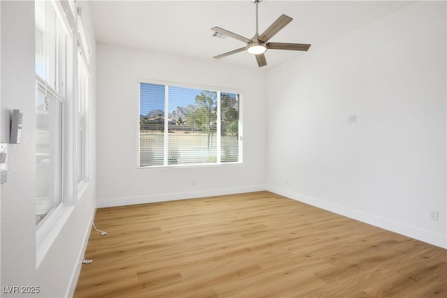 empty room featuring light wood-type flooring, visible vents, and baseboards