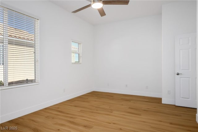 unfurnished room featuring baseboards, a ceiling fan, and light wood-style floors