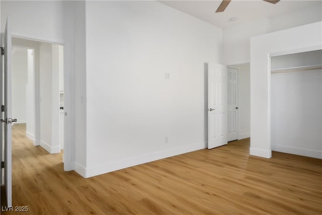 unfurnished bedroom with light wood finished floors, a closet, baseboards, and a ceiling fan