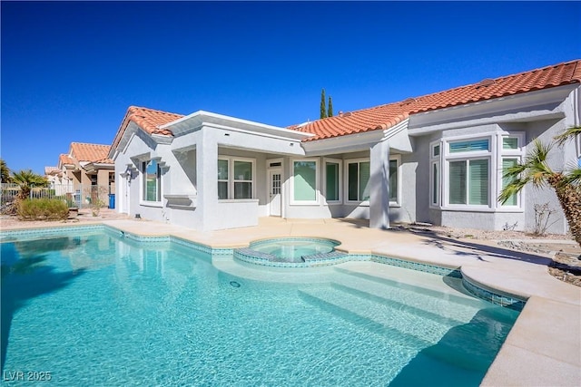 rear view of house with a pool with connected hot tub, a patio, a tiled roof, and stucco siding