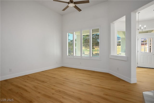 unfurnished room with baseboards, a wealth of natural light, and light wood-style floors