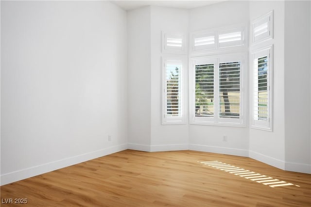 unfurnished room featuring light wood-type flooring and baseboards