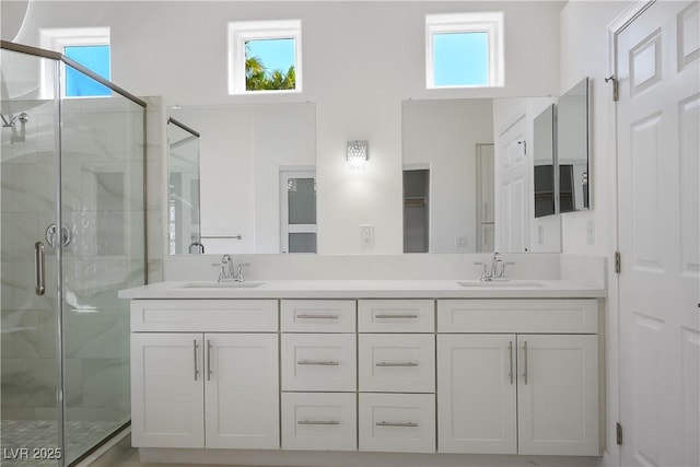 full bath with double vanity, a shower stall, and a sink