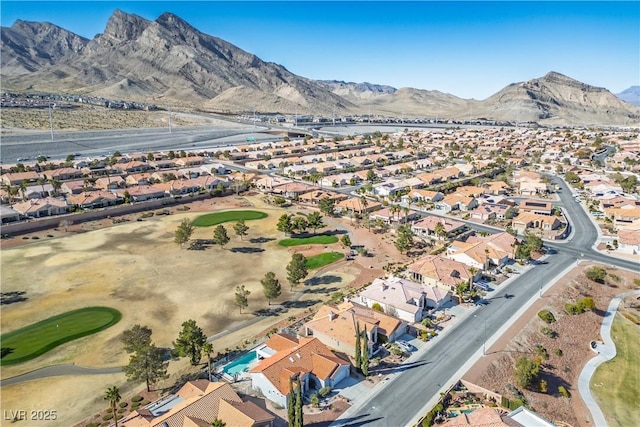 drone / aerial view with a residential view, a mountain view, and golf course view