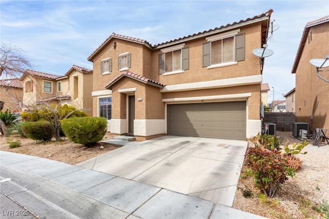 mediterranean / spanish-style house featuring central air condition unit, stucco siding, driveway, an attached garage, and a tiled roof