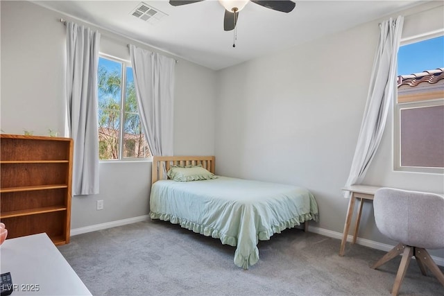 carpeted bedroom featuring baseboards, visible vents, and a ceiling fan